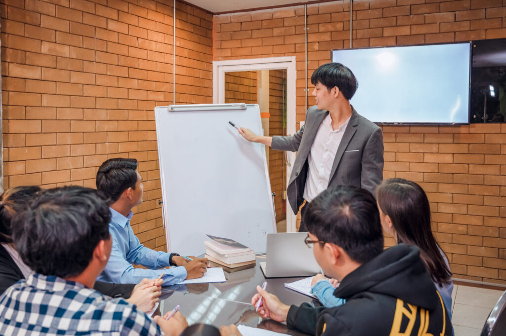 Team brainstorming innovative ideas during a presentation. Implementing innovation management systems.