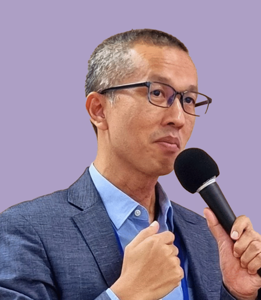 Man in suit speaking at microphone, business conference